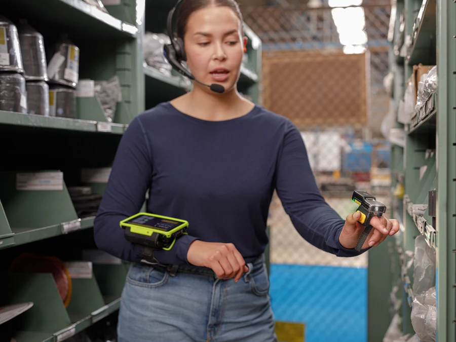 Zebra warehouse worker wearing a headset and wearable computer while using a ring scanner