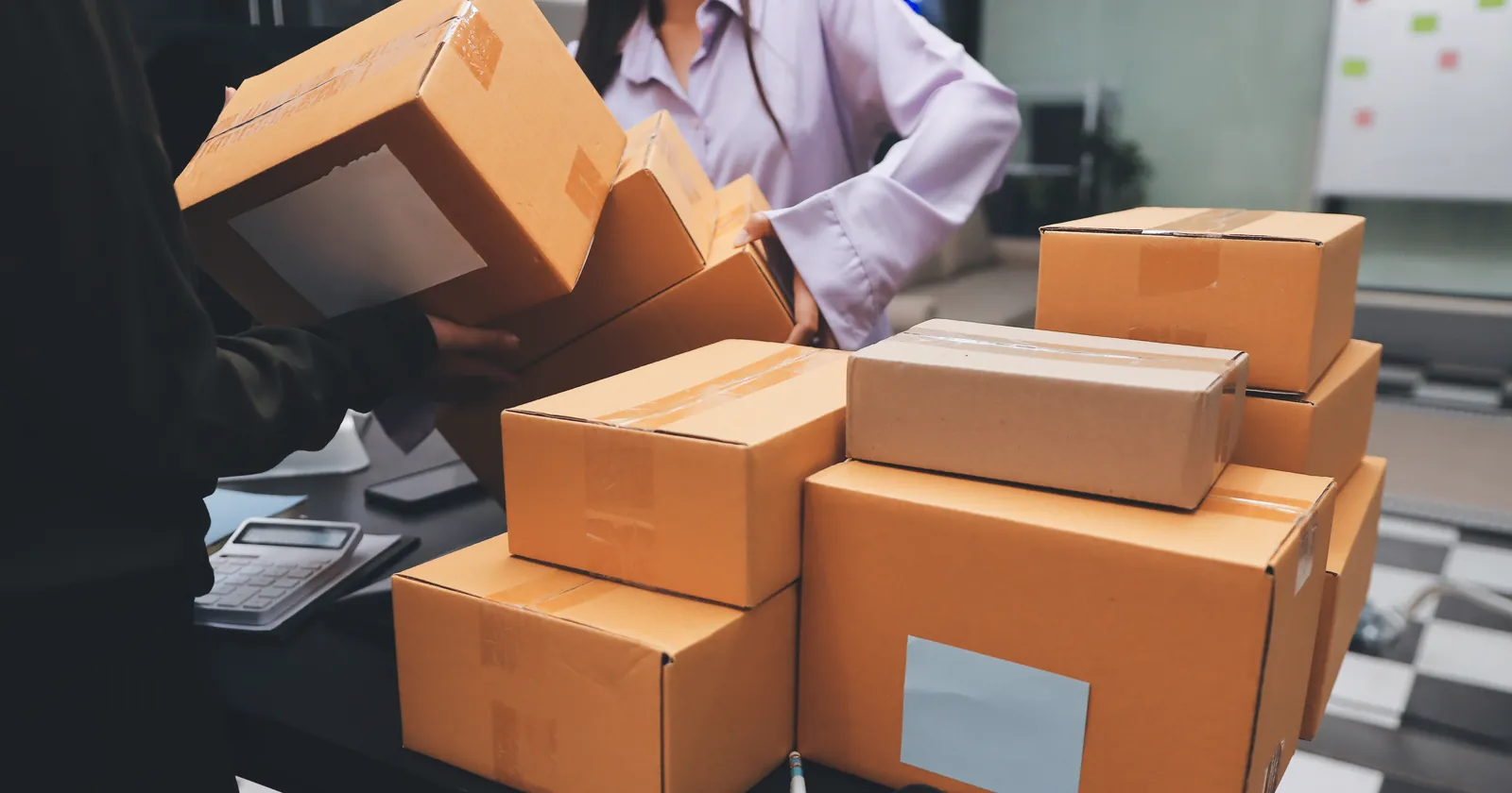 Warehouse staff packing webshop orders into cartons