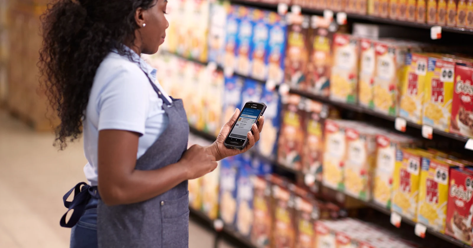 Store associate using a Zebra handheld at retail shelves