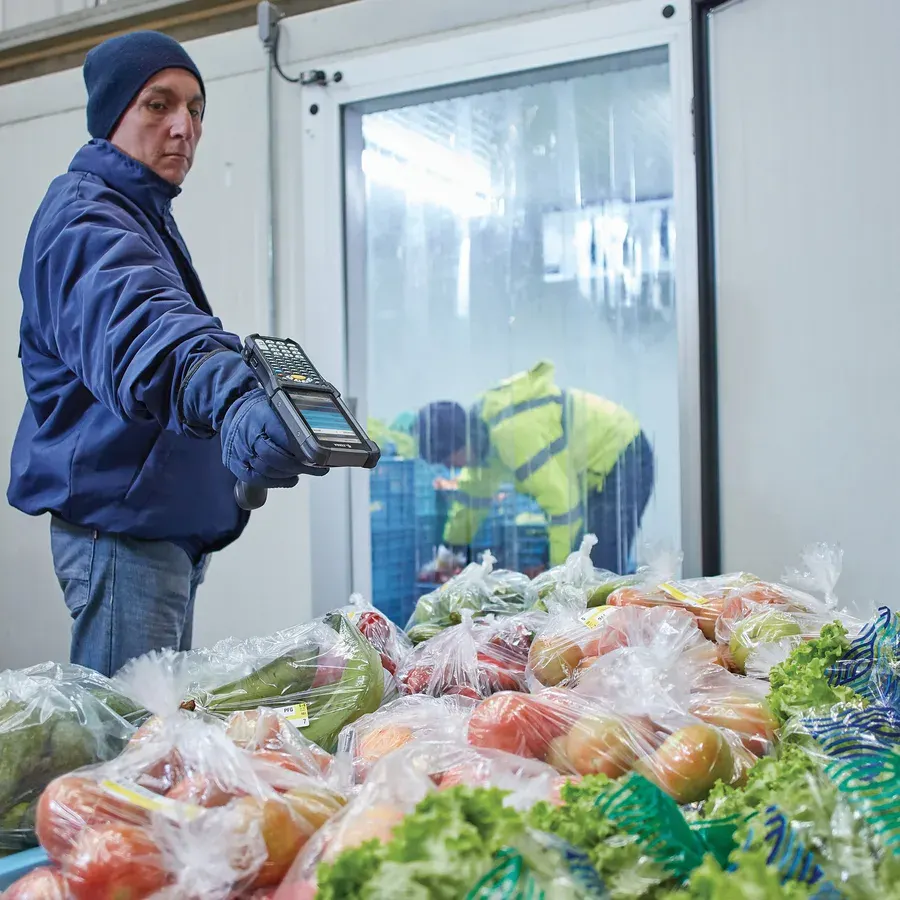 Stock count with a handheld barcode scanner in a warehouse aisle