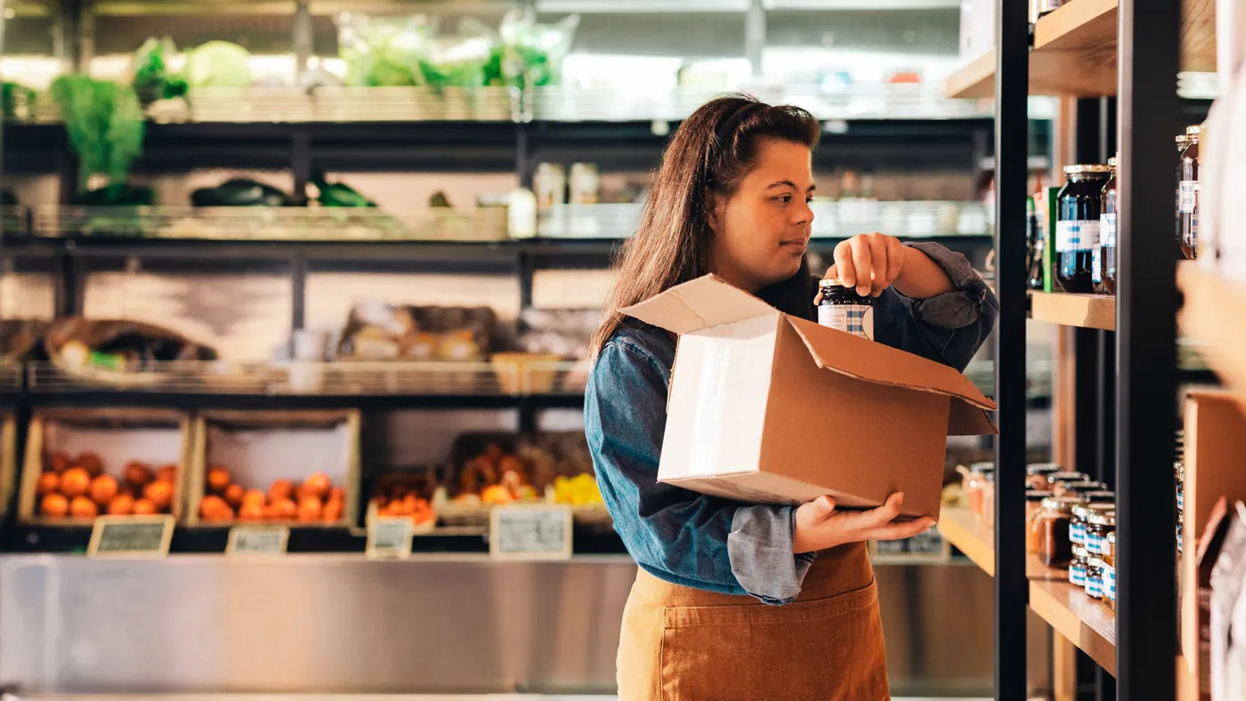 Employé de magasin comptant le stock, un carton à la main